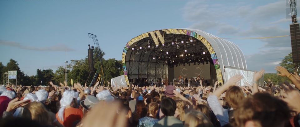 Long shot of crowds and performers on stage at Wilderness event